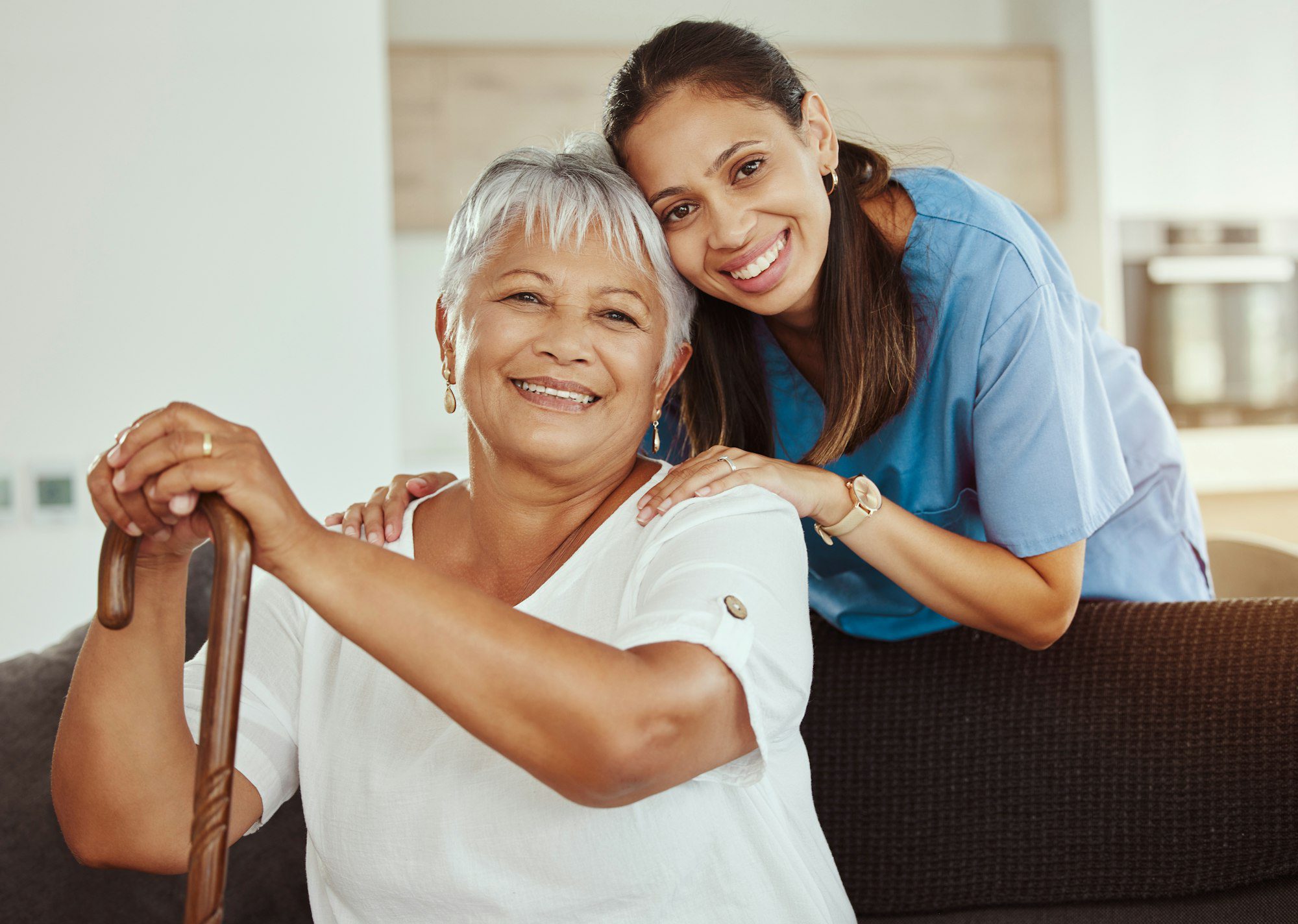 Caregiver and older adult sitting together at home, representing in-home and home health care support